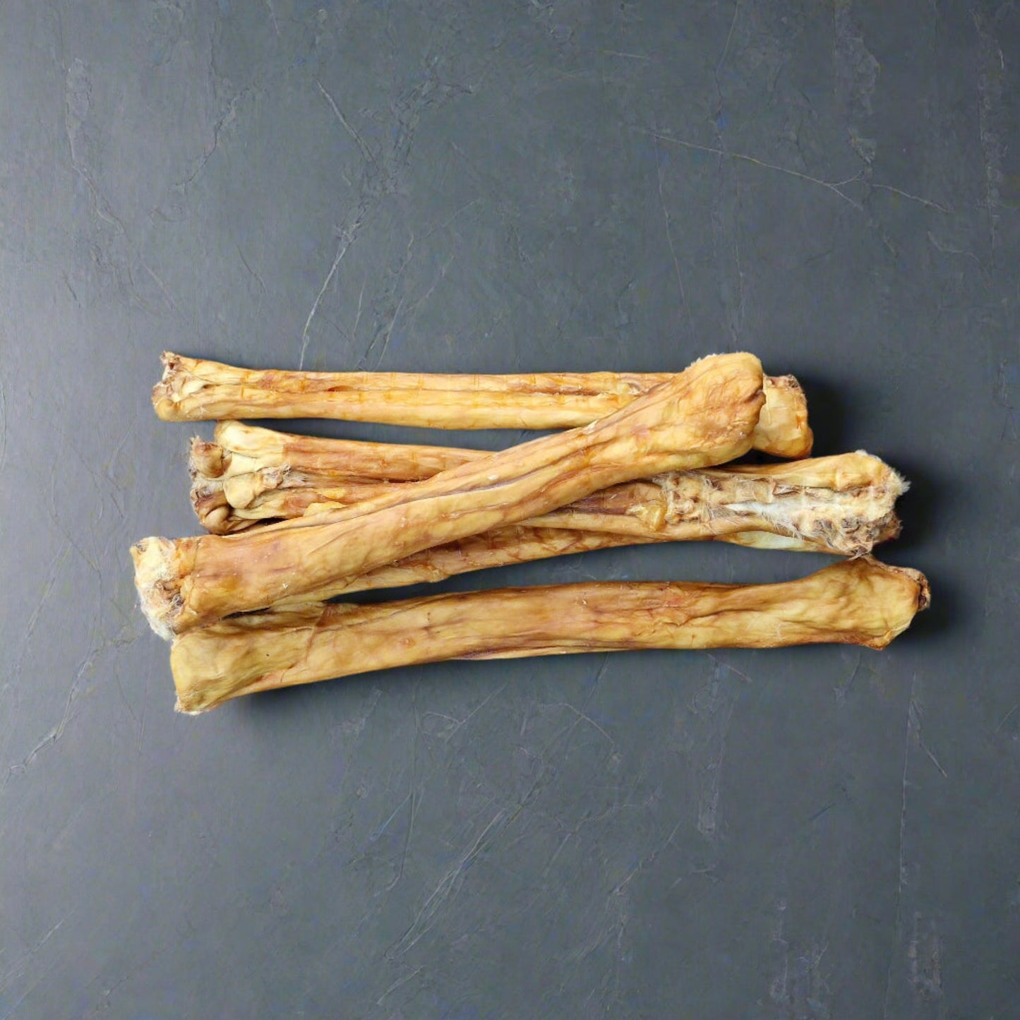 4 rolled rabbit pelts on a slate background