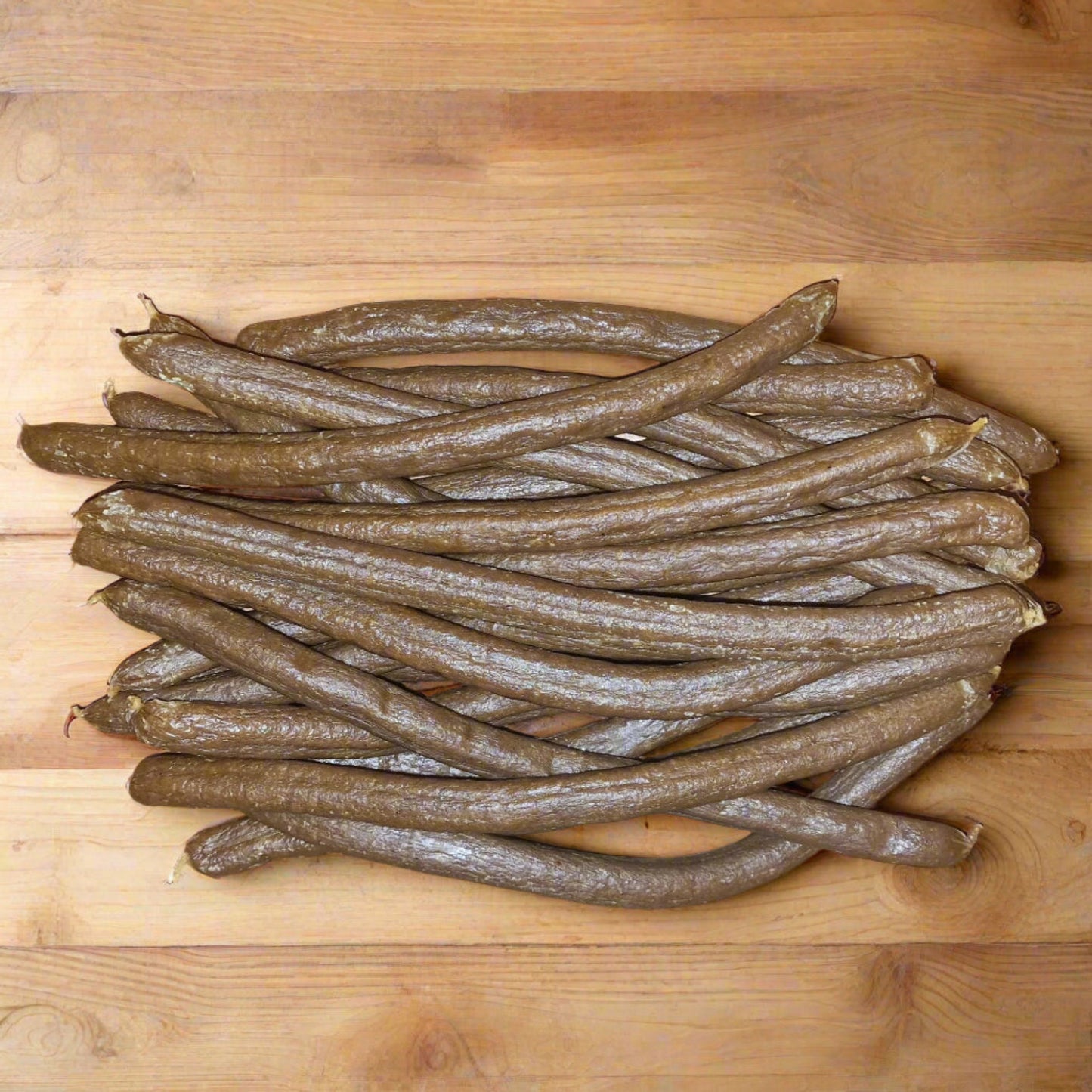 pile of lamb & chicken sausages on a wooden surface