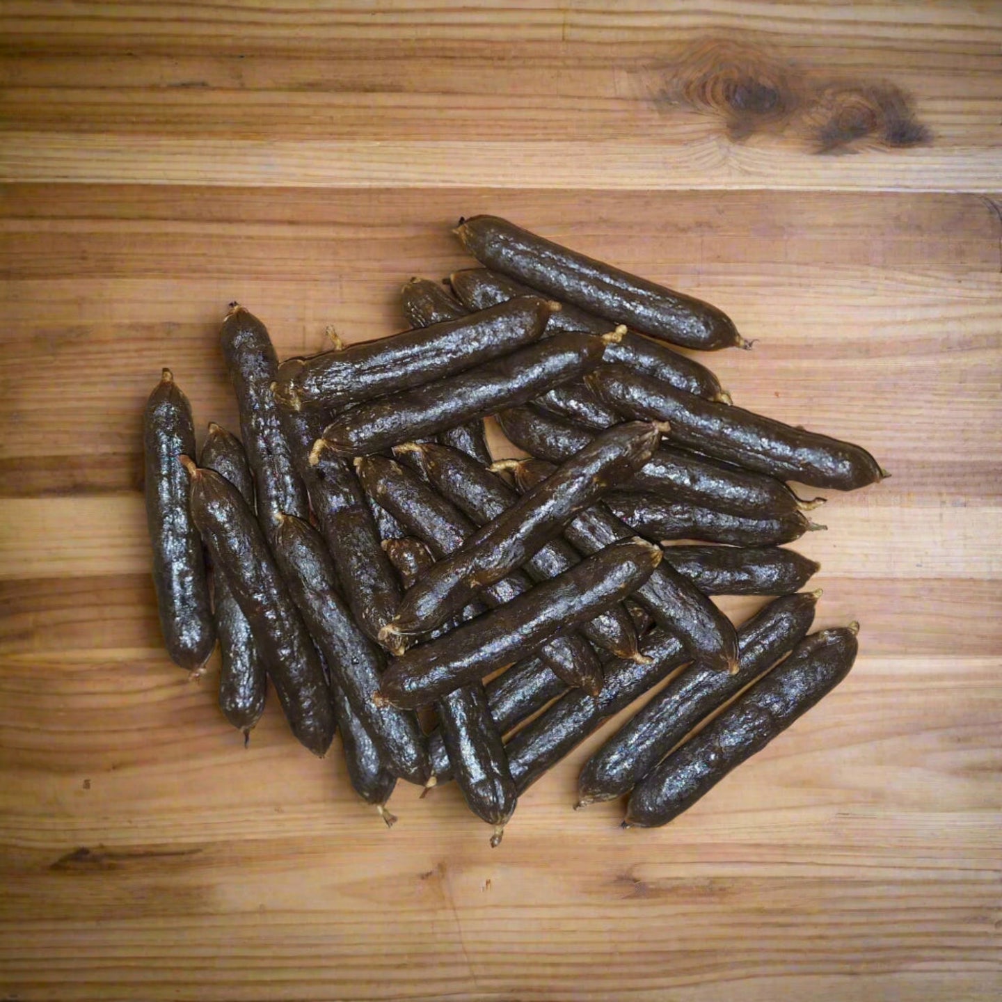 pile of medium pork sausages on a wooden surface