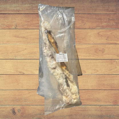 A sealed bag of Hilltop Pet Food Furry Rabbit Skin (Pelt) on a wooden surface.