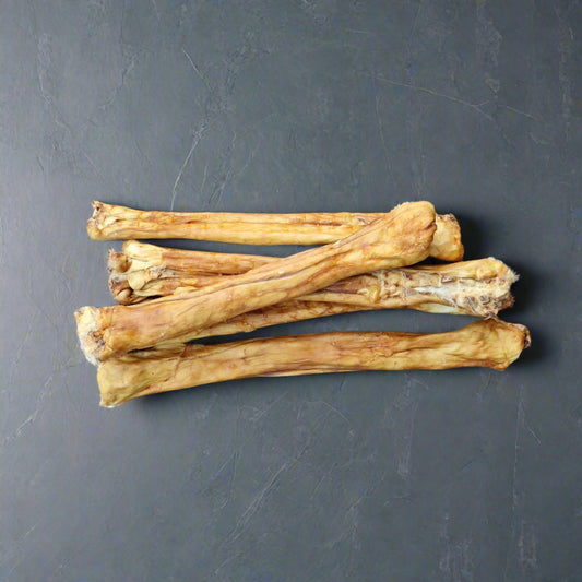 4 rolled rabbit pelts on a slate background