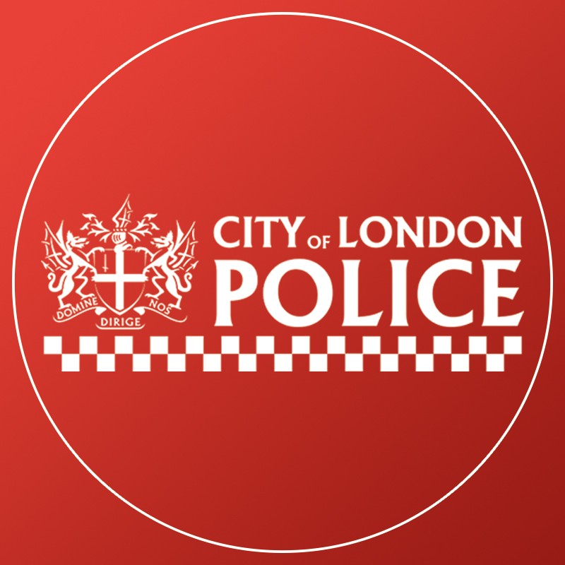 City of London Police logo with a crest, checkerboard pattern, and text on a red background.