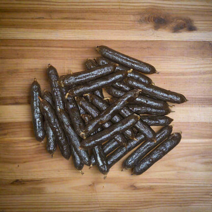 pile of medium pork sausages on a wooden surface